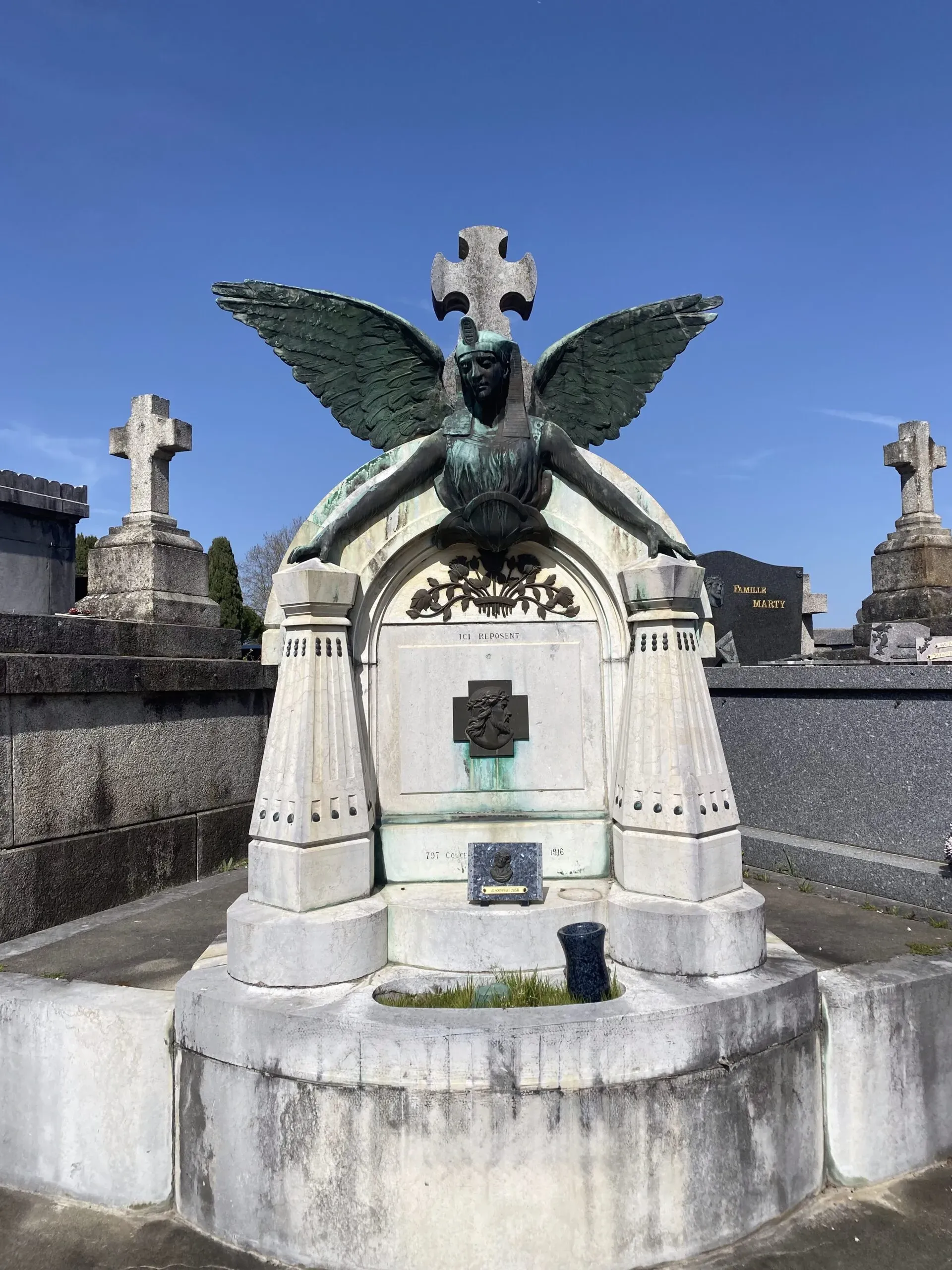 Monument funéraire en pierre avec statue d'ange sculpté au cimetière.