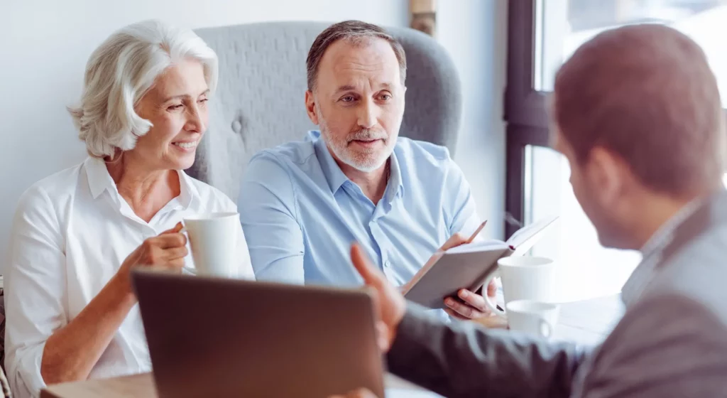 Couple de seniors en rendez-vous d'information avec un conseiller en prévoyance.