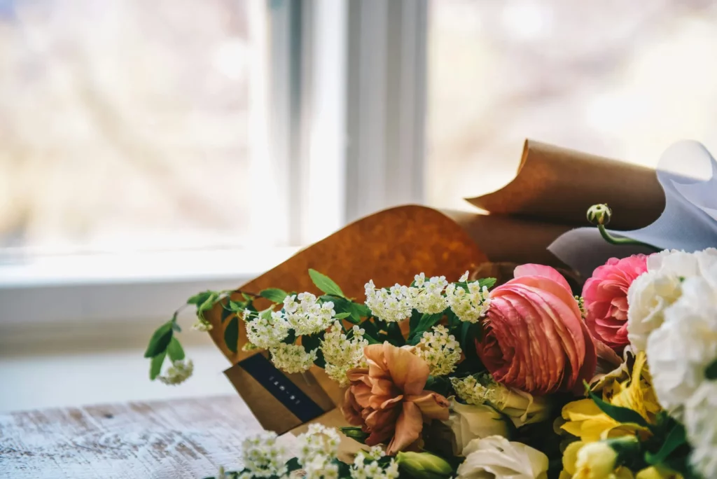 Bouquet de fleurs fraîches de saison emballé dans du papier kraft élégant.